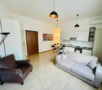 a living room with a couch and a chair and a kitchen at INTERNO DIECI in Rome