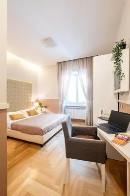 a bedroom with a bed and a desk with a laptop at Rome River Inn in Rome