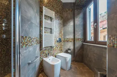 a bathroom with a toilet and a sink and a shower at 900 Apartments Veneto & Pinciana in Rome