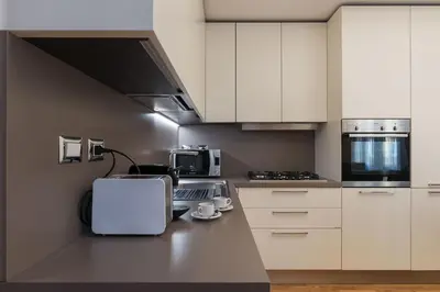 a kitchen with white cabinets and a counter top at 900 Apartments Veneto & Pinciana in Rome