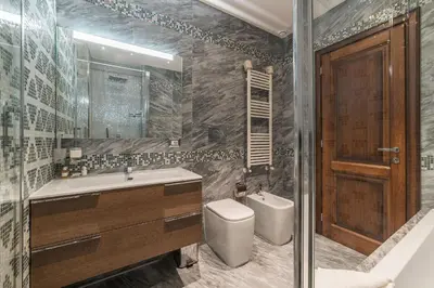 a bathroom with a sink and a toilet and a mirror at 900 Apartments Veneto & Pinciana in Rome