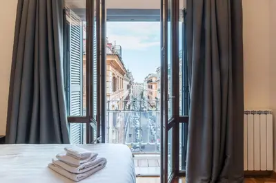 a bedroom with a view of a city from a window at 900 Apartments Veneto & Pinciana in Rome