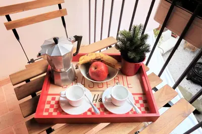a table with a tray with a plate of fruit and coffee cups at San Callisto in Rome