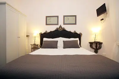 a bedroom with a large bed with two pillows at Amica Roma Guest House in Rome