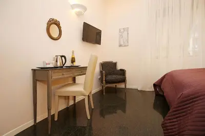 a bedroom with a desk and a bed and a desk and chair at Amica Roma Guest House in Rome