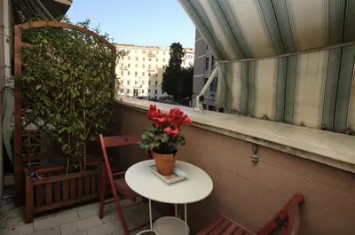 a table with a vase of flowers on a balcony at Amica Roma Guest House in Rome