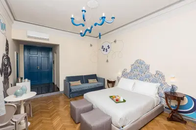 a bedroom with a bed and a couch in a room at Tritone 125 Suite in Rome