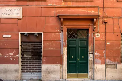 a green door on the side of a red building at TrevInn Suites in Rome