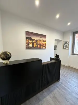 a waiting room with a counter and a painting on the wall at TrevInn Suites in Rome