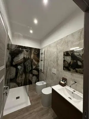 a bathroom with a sink and a toilet and a shower at TrevInn Suites in Rome
