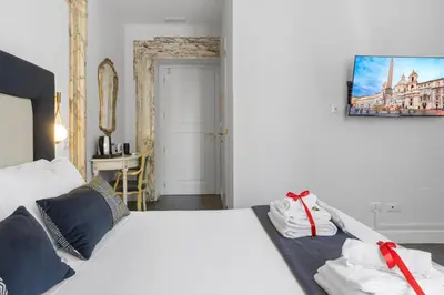 a bedroom with a white bed with two towels on it at GHR Navona Inn in Rome