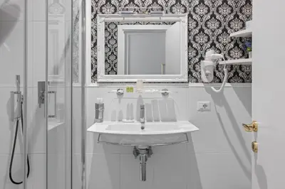 a bathroom with a sink and a mirror and a shower at GHR Navona Inn in Rome