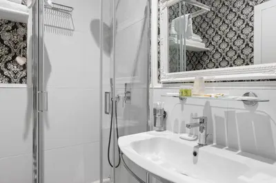 a white bathroom with a sink and a shower at GHR Navona Inn in Rome