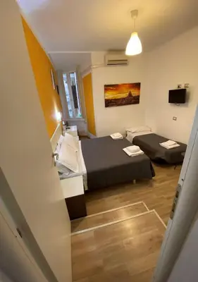 a small room with two beds and a television at B&B A Home in Rome in Rome