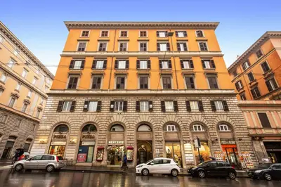 a large building with cars parked in front of it at AMICI GUESTHOUSE in Rome