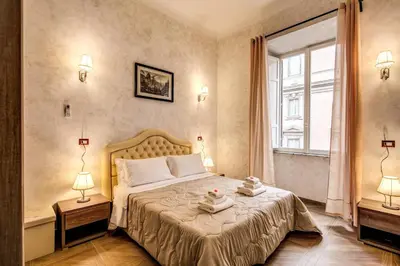 a bedroom with a bed with two lamps and a window at AMICI GUESTHOUSE in Rome