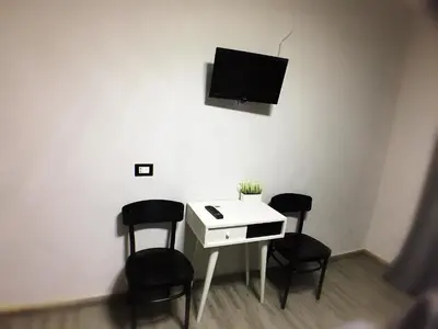 a room with a desk with chairs and a tv on the wall at Babyface in Rome