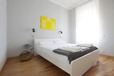 a white bedroom with a white bed with towels on it at San Peter Apartment - your home in the heart of Rome in Rome