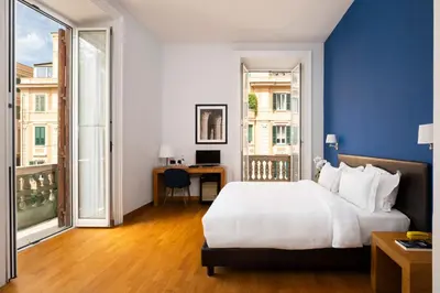 a bedroom with a large white bed and a desk at Sky Blue Place Rome in Rome