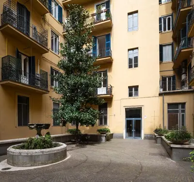 an apartment building with a tree in the courtyard at Sky Blue Place Rome in Rome