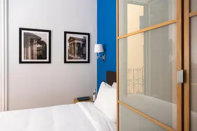 a bedroom with a white bed and two framed pictures at Sky Blue Place Rome in Rome
