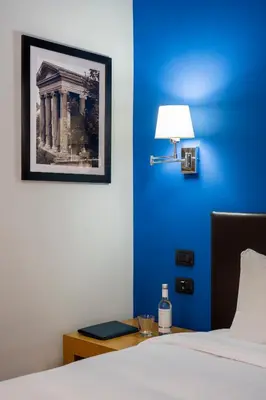 a bedroom with a blue wall with a bed and a lamp at Sky Blue Place Rome in Rome
