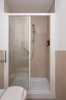 a shower with a glass door in a bathroom at Sky Blue Place Rome in Rome