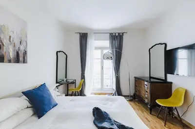 a bedroom with a bed and two yellow chairs at Elegant Apartment Via Veneto by Varental in Rome