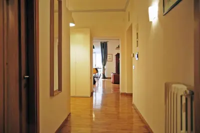 an empty hallway with a wooden floor in a house at Elegant Apartment Via Veneto by Varental in Rome