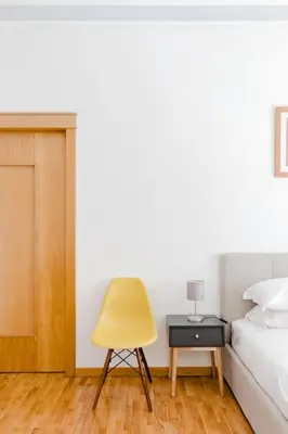 a bedroom with a bed and a yellow chair at Elegant Apartment Via Veneto by Varental in Rome