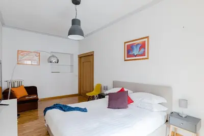 a bedroom with a white bed and a yellow chair at Elegant Apartment Via Veneto by Varental in Rome