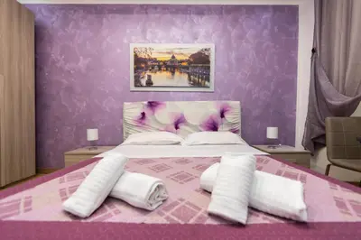 a purple bedroom with a bed with white pillows at Imperiale Top in Rome