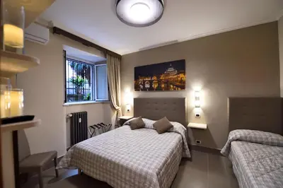 a bedroom with two beds and a large window at Domus Catone in Rome