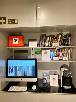 a desk with a computer on a shelf with books at B&B Best Pantheon in Rome