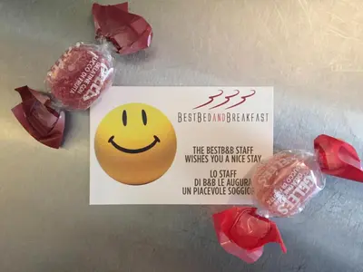 a sign with a smiley face on it next to flowers at B&B Best Pantheon in Rome