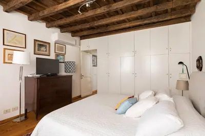a bedroom with a white bed and a television at Farnese Charming Apartment in Rome