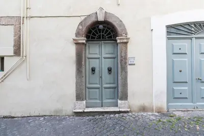 a building with two blue doors on the side at Farnese Charming Apartment in Rome