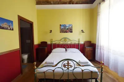 a bedroom with a bed in a yellow room at Old Bakery Rome GuestHouse in Rome