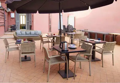 a group of tables and chairs with an umbrella at Old Bakery Rome GuestHouse in Rome