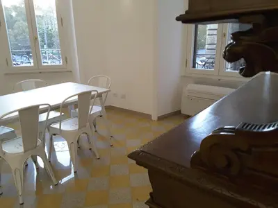 a dining room with a table and chairs and windows at Dino Apartment in Rome