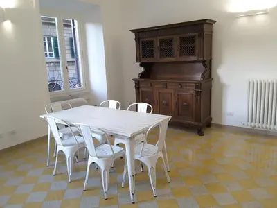 a white table with white chairs and a wooden cabinet at Dino Apartment in Rome