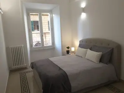 a bedroom with a large bed and a window at Dino Apartment in Rome