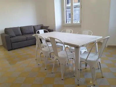 a table and chairs in a living room with a couch at Dino Apartment in Rome