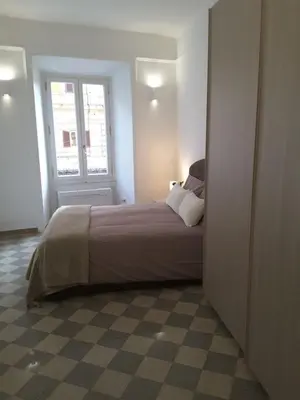 a bedroom with a large bed with a window at Dino Apartment in Rome