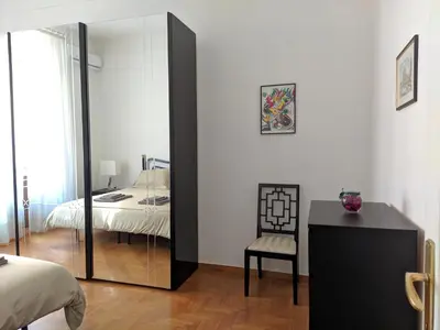 a bedroom with a mirror and a chair and a bed at My Enchanting Roman Holiday in Rome