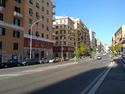 an empty city street with parked cars and buildings at My Enchanting Roman Holiday in Rome
