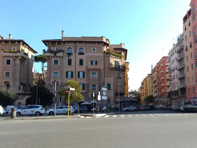 a city street with cars parked in front of buildings at My Enchanting Roman Holiday in Rome