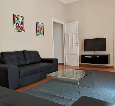a living room with a black couch and a glass coffee table at My Enchanting Roman Holiday in Rome