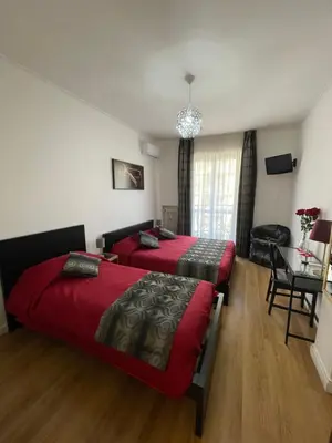 a bedroom with two beds and a table with a chair at Trastevere Sweet Rest in Rome
