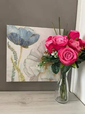 a vase filled with pink roses in front of a painting at Trastevere Sweet Rest in Rome